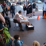 A gentleman in Old Town plays the glass harp before a crowd