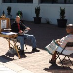 A gentlemen draws a caricature of a lady at the waterfront